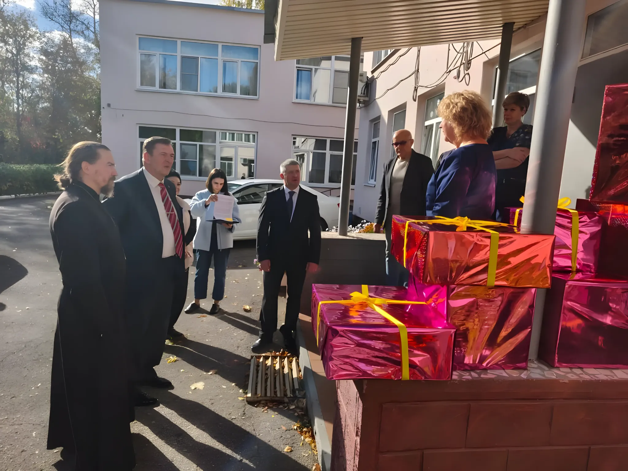 Участники встречи рядом с переданной благотворительной помощью